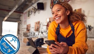 Smiling small business owner holding a phone.